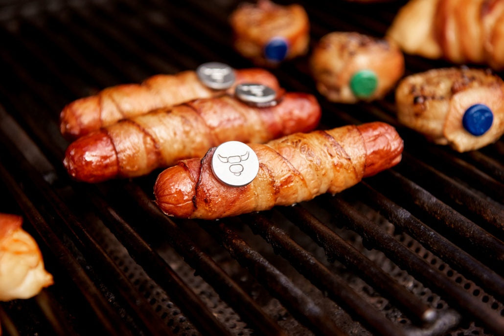 Hot dog wrapped in bacon tucked with Grill Pin